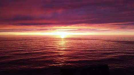 beautiful aerial vibrant high contrast pink purple sunset over baltic sea, karosta war port concrete coast fortification ruins at liepaja, wide angle drone shot moving backwards