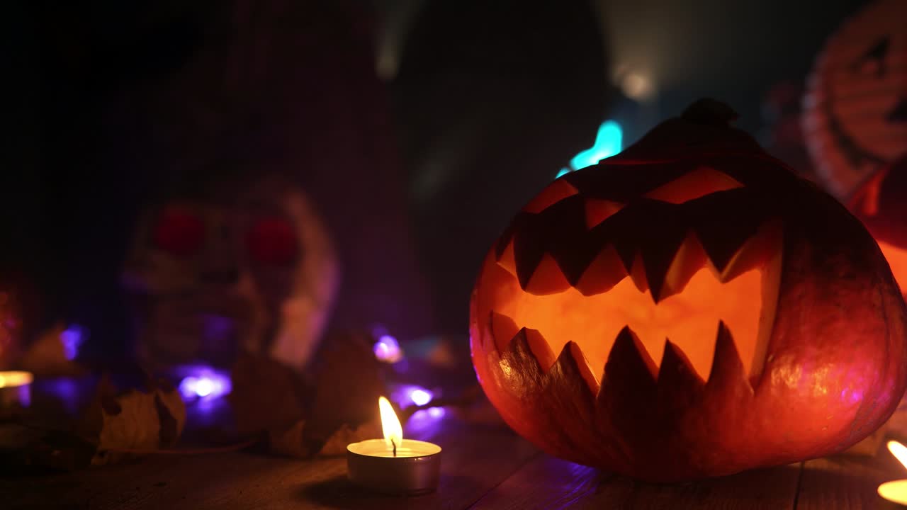 잭 오 랜턴은 불타는 불꽃과 함께 나무 테이블에 서 있습니다.