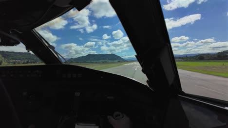 Immersive-plot-POV-as-seen-by-the-pilot-of-a-jet-taking-off-from-a-very-short-runway-surrounded-by-green-fields-and-a-mountainous-landscape