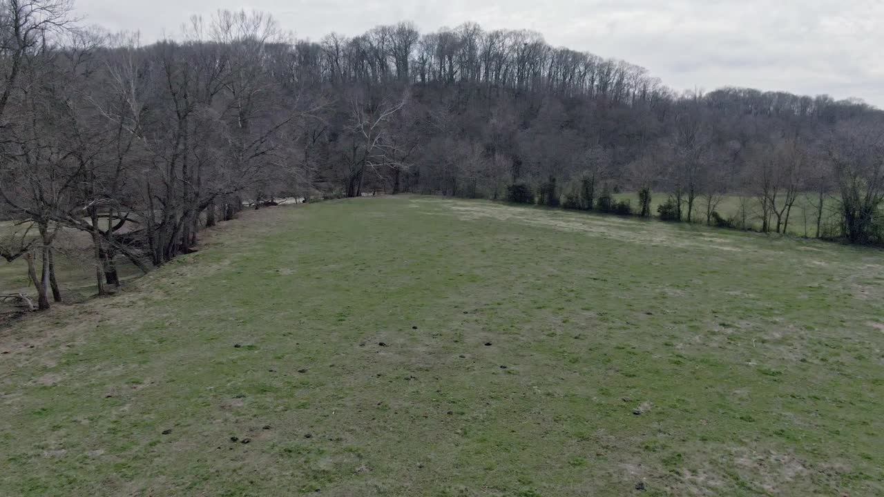 low altitude aerial view of pasture with a curved flight pattern toward the river