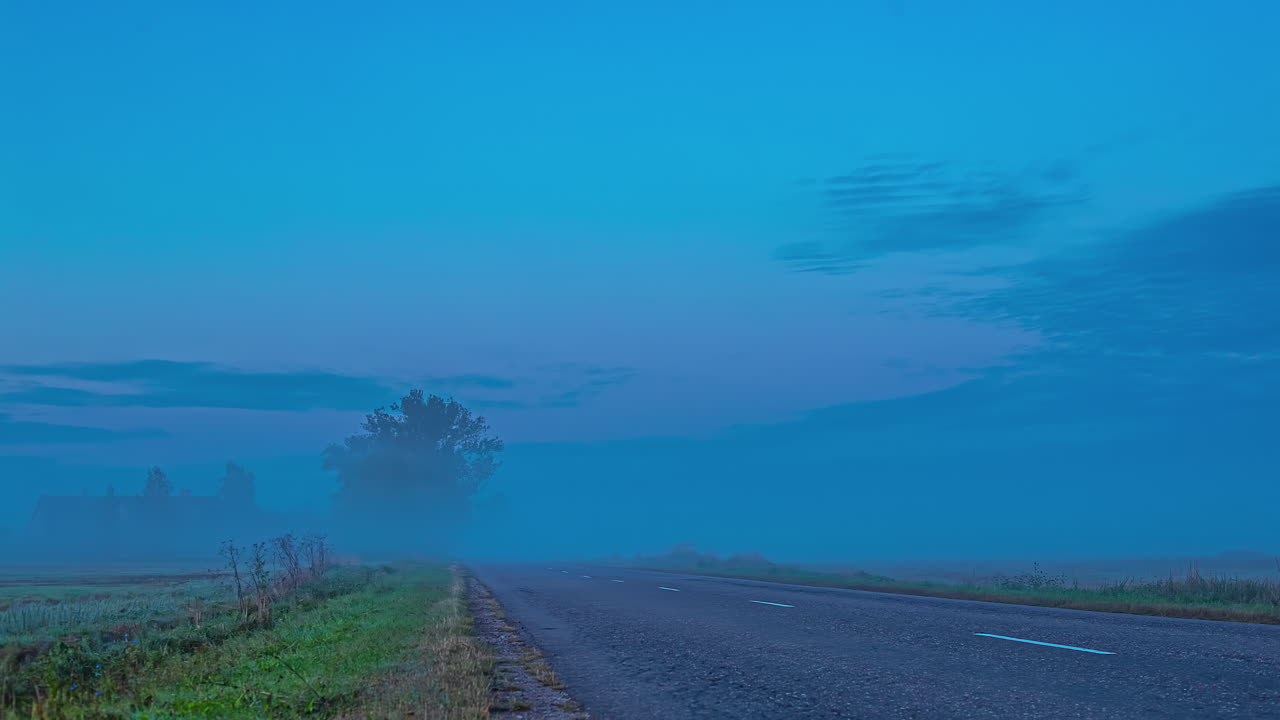대낮에 자동차가 다니는 안개 낀 길. 타임랩스