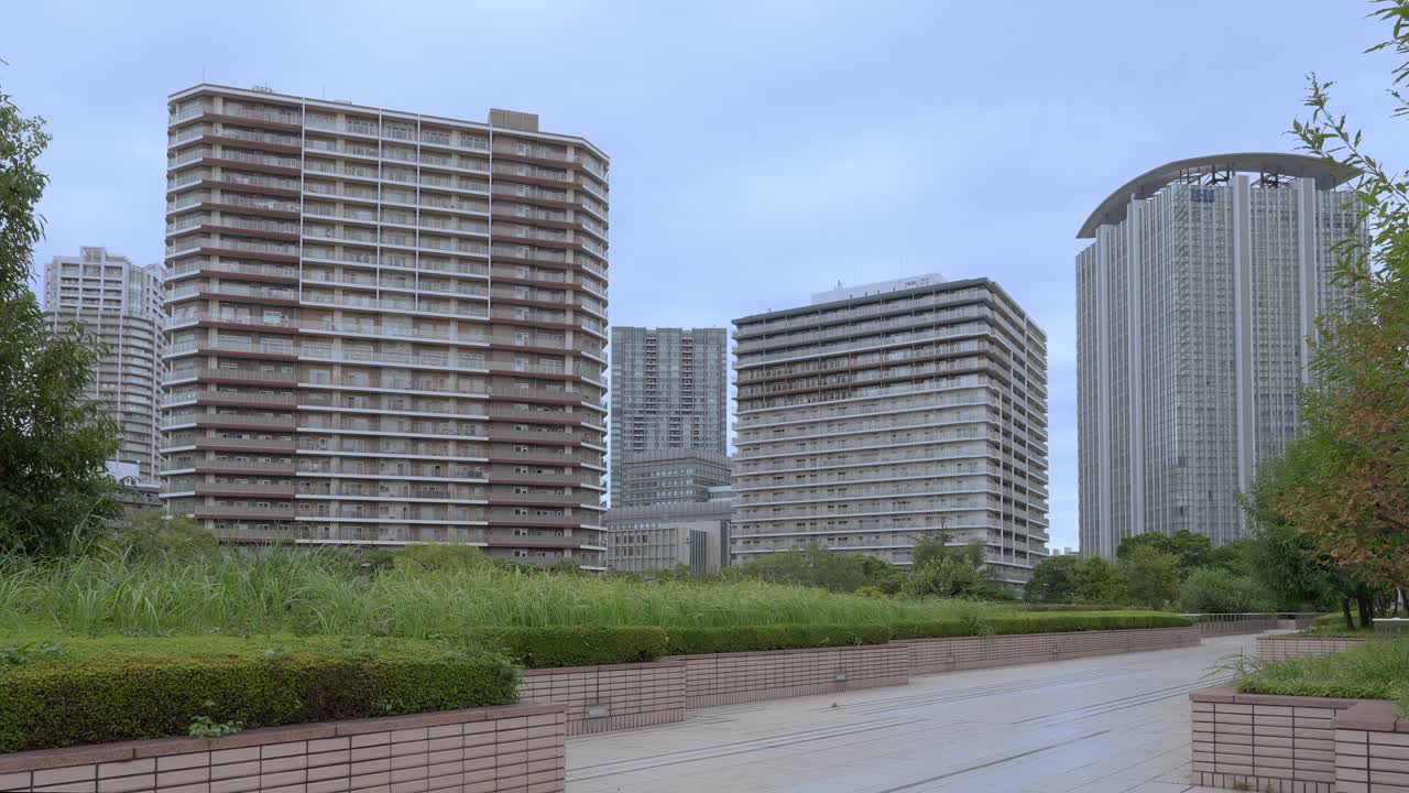 A wide shot of large apartment and residential buildings in Tokyo against an overcast sky