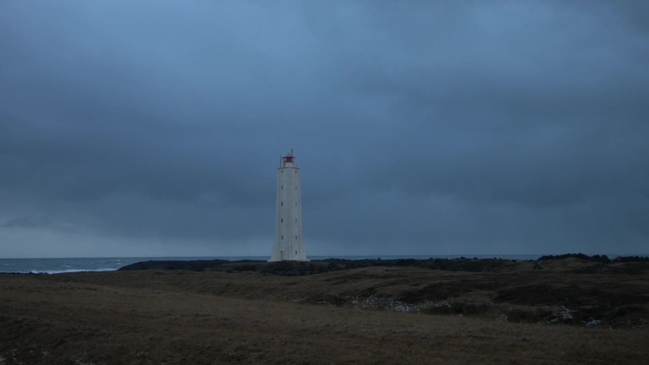 Giornata nuvolosa e un faro solitario su una spiaggia islandese