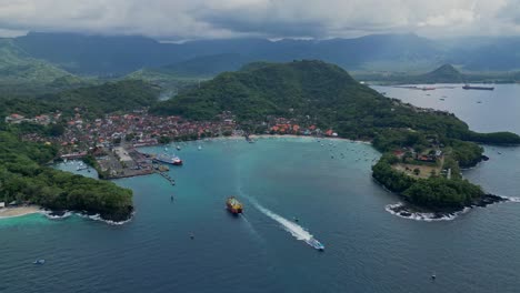 Orbitaldrohnenansicht-Von-Padang-Bai-Auf-Bali-Mit-Fähren,-Die-In-Den-Hafen-Ein--Und-Ausfahren