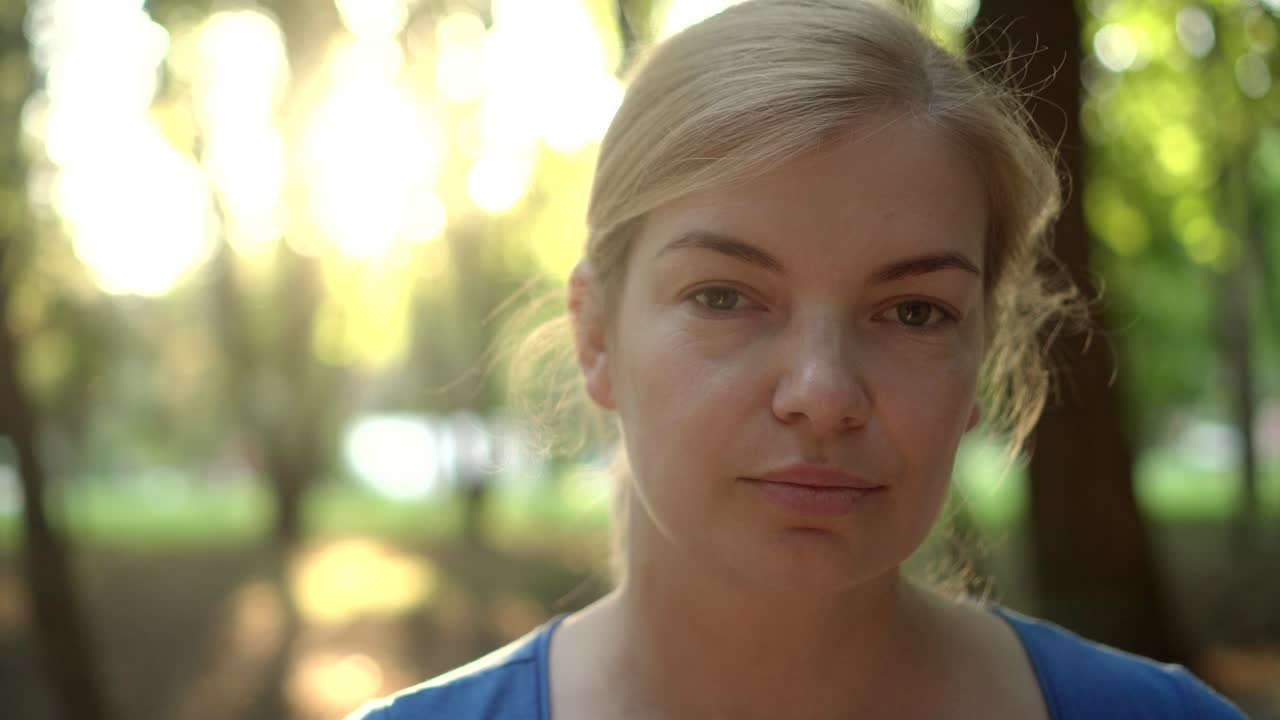 una mujer se quita una máscara médica en un parque 05