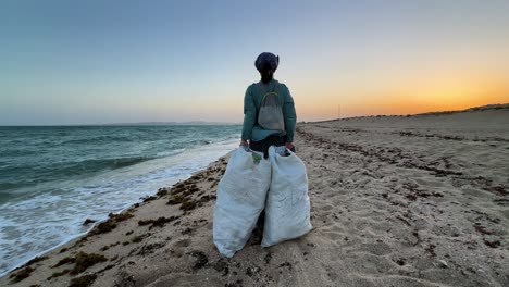 Tragen-Eines-Müllsacks-Am-Strand-Entlang,-Küstenlandschaft-Mit-Sauberer-Umwelt,-Sonnenuntergangshimmel-Im-Hintergrund,-Wundervoller-Panorama-Weitblick-Auf-Die-Reise-In-Den-Nahen-Osten,-Asien,-Vereinigte-Arabische-Emirate,-Sandstrand,-Katar,-Natürliche-Attraktion