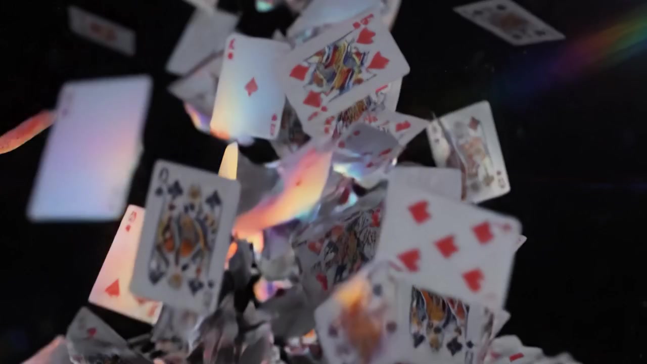 Una sequenza spettacolare di carte da gioco che cadono catturate nello spazio, mettendo in risalto il movimento vibrante e l'illuminazione di ogni carta mentre si riversano nell'aria.