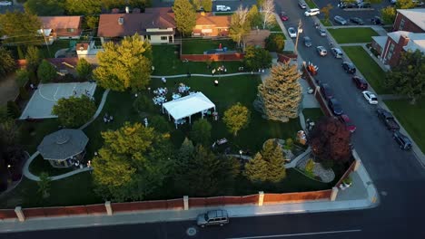 bird's eye view aerial shot of a backyard outdoor wedding reception in a suburban neighborhood on a bright warm summer day