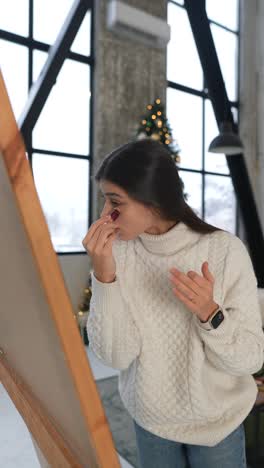 woman applying makeup in front of a mirror during christmas