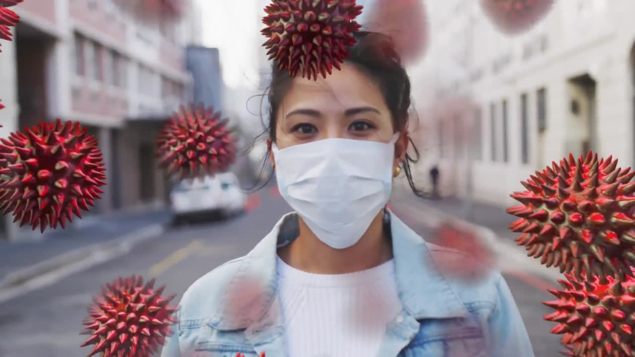 Animation of macro coronavirus Covid-19 cells spreading over a mixed race woman wearing a mask