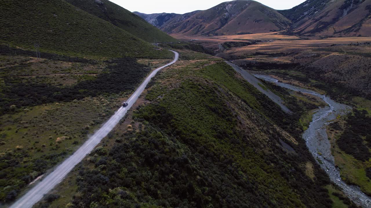 Drone tracking a vehicle driving in the wilderness of Canterbury, in cloudy NZ