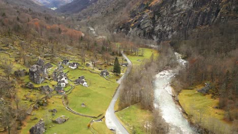 idyllic view down the valley: a river runs at the bottom of mountains, a road curling along the scattered houses