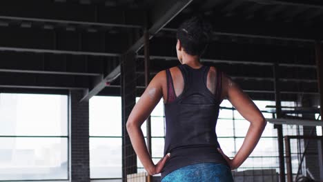 African-american-woman-standing-and-resting-after-exercise-in-an-empty-urban-building