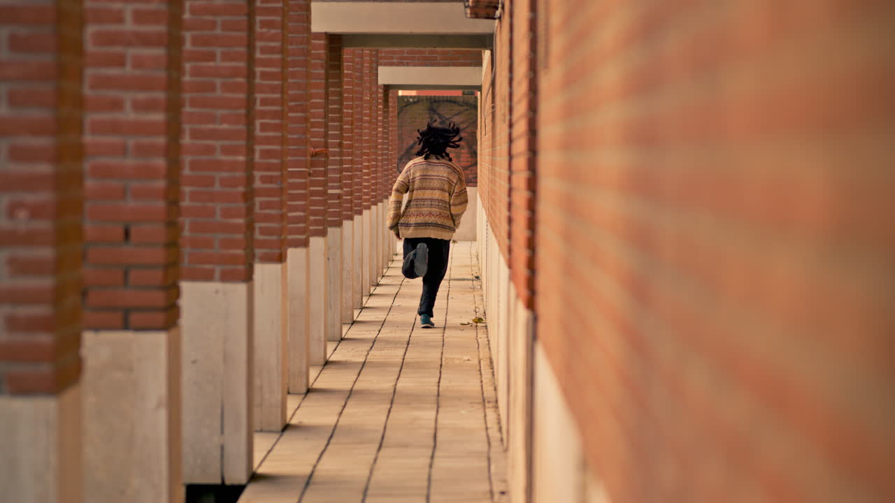 Person Running Through Brick Alleyway