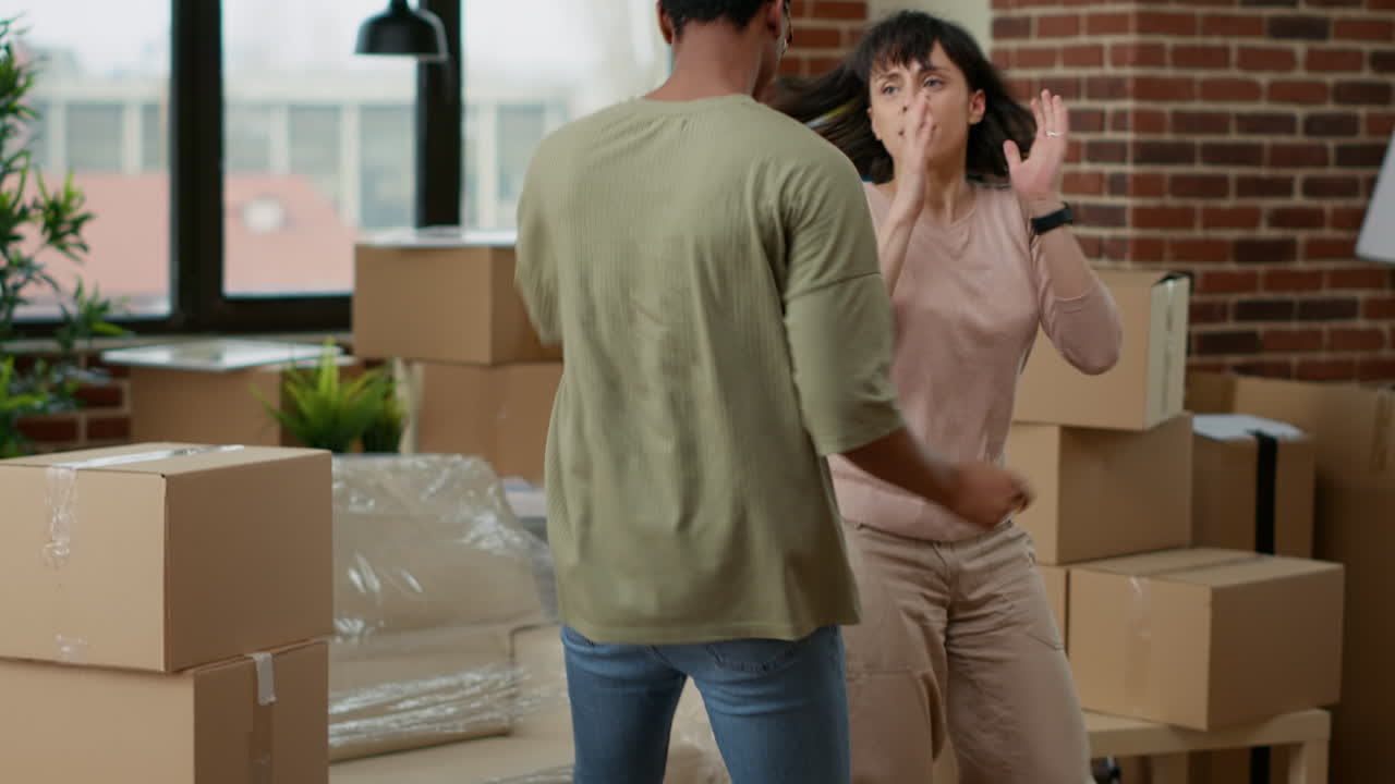 Married people celebrating household relocation and doing dance moves