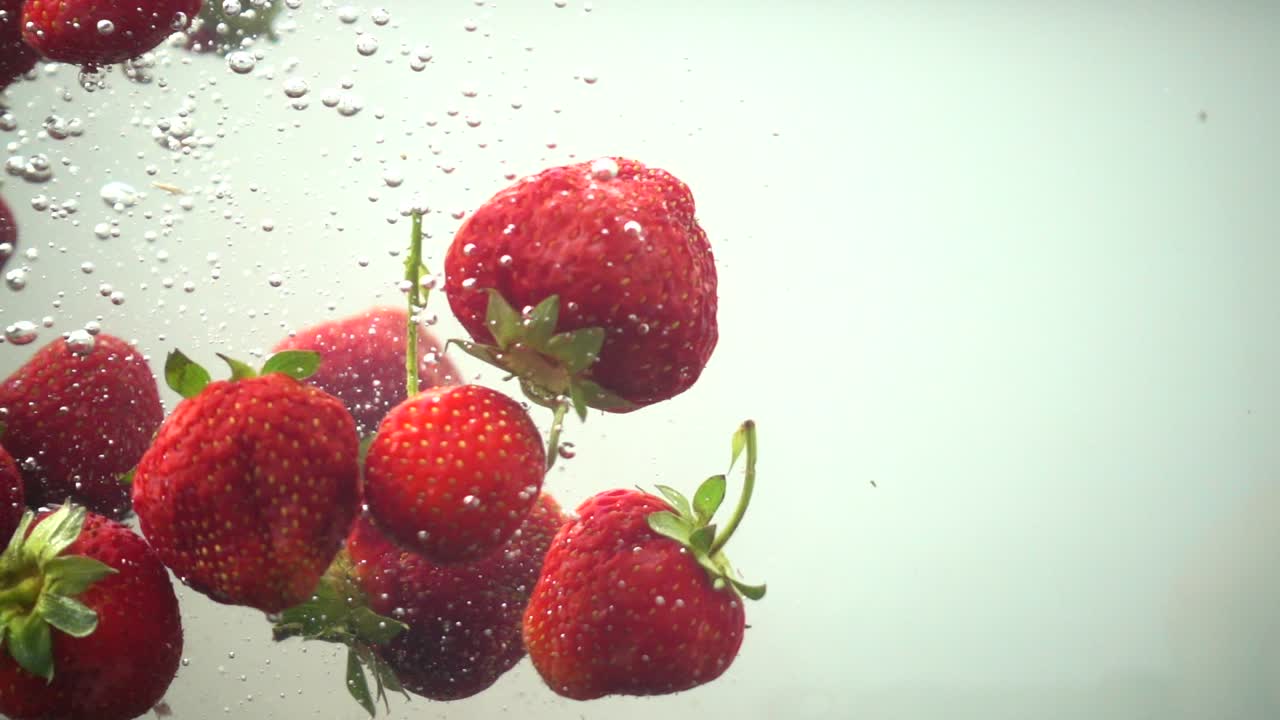 The falling strawberry in water. Slow motion