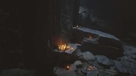 candles illuminate ancient rocks in a dark mystical setting at night