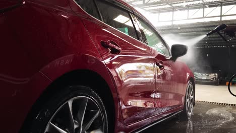 red car being washed in a car wash