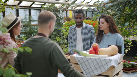 people shopping at a greenhouse farmers market