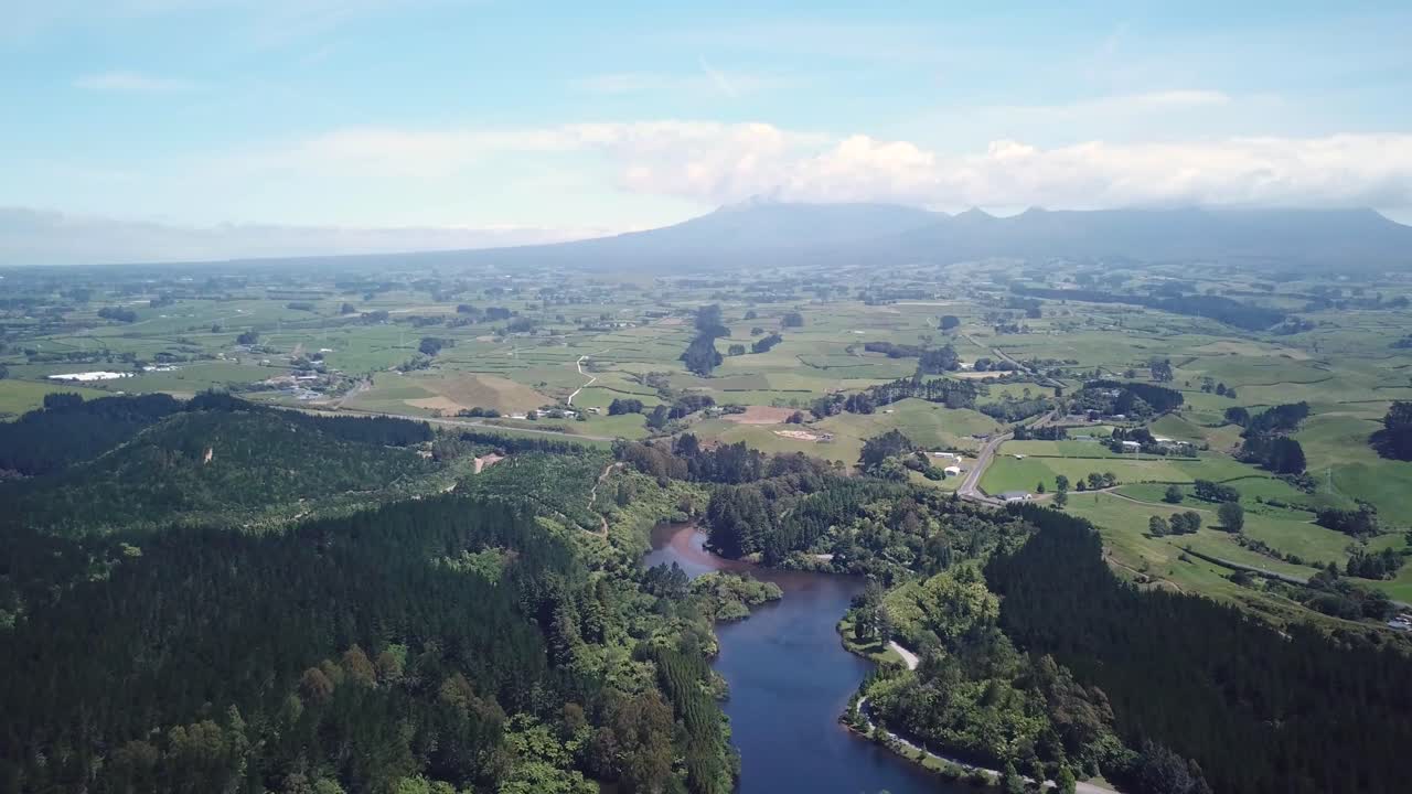 뉴질랜드 뉴플리머스에 있는 타라나키 산의 아름다운 풍경과 함께 호수와 숲 위로 높이 날아가는 공중 촬영