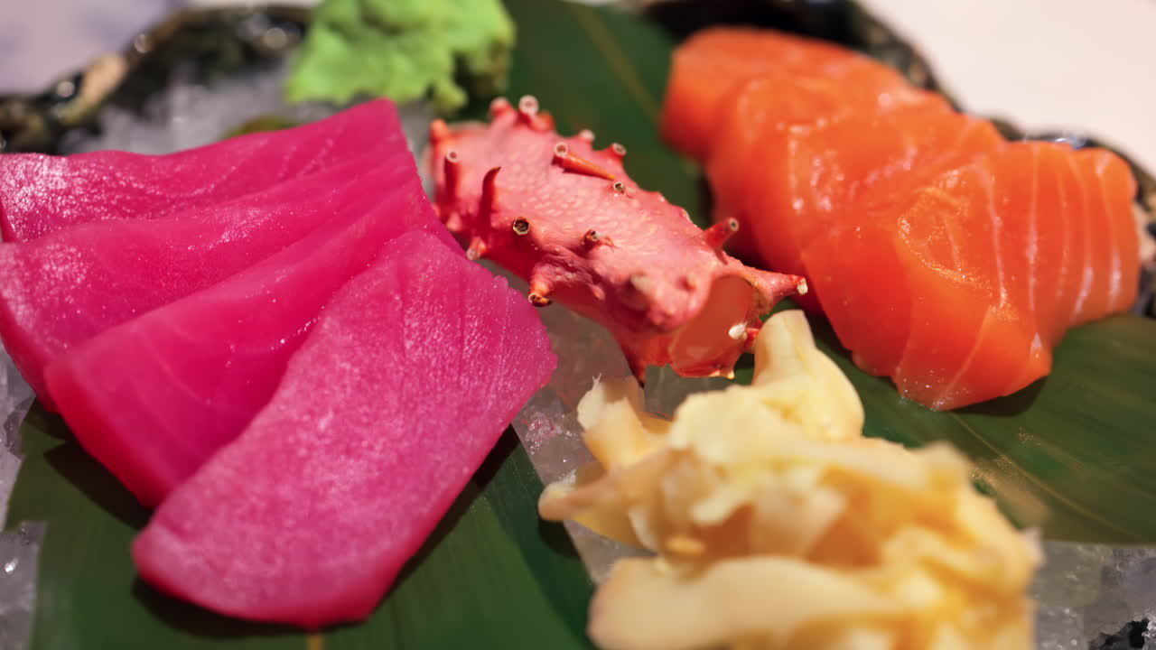Close up of tuna and salmon sashimi on banana leaves on ice