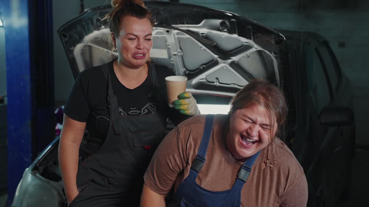 Two Women Mechanics Laughing in a Garage