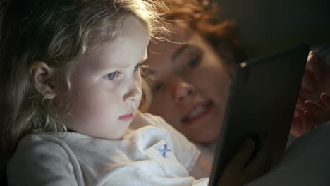 mother lying with her daughter in bed