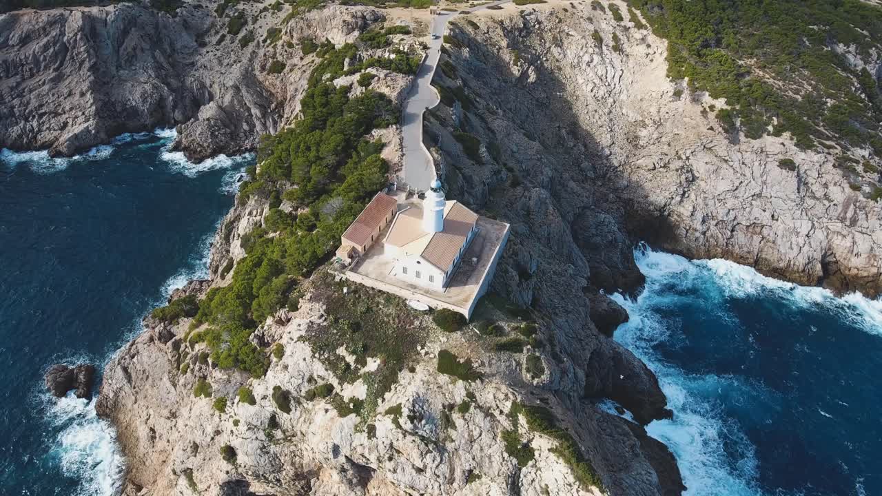 4k drone footage of a lighthouse in Cala Ratjada, Mallorca with a stormy mediterranean sea.