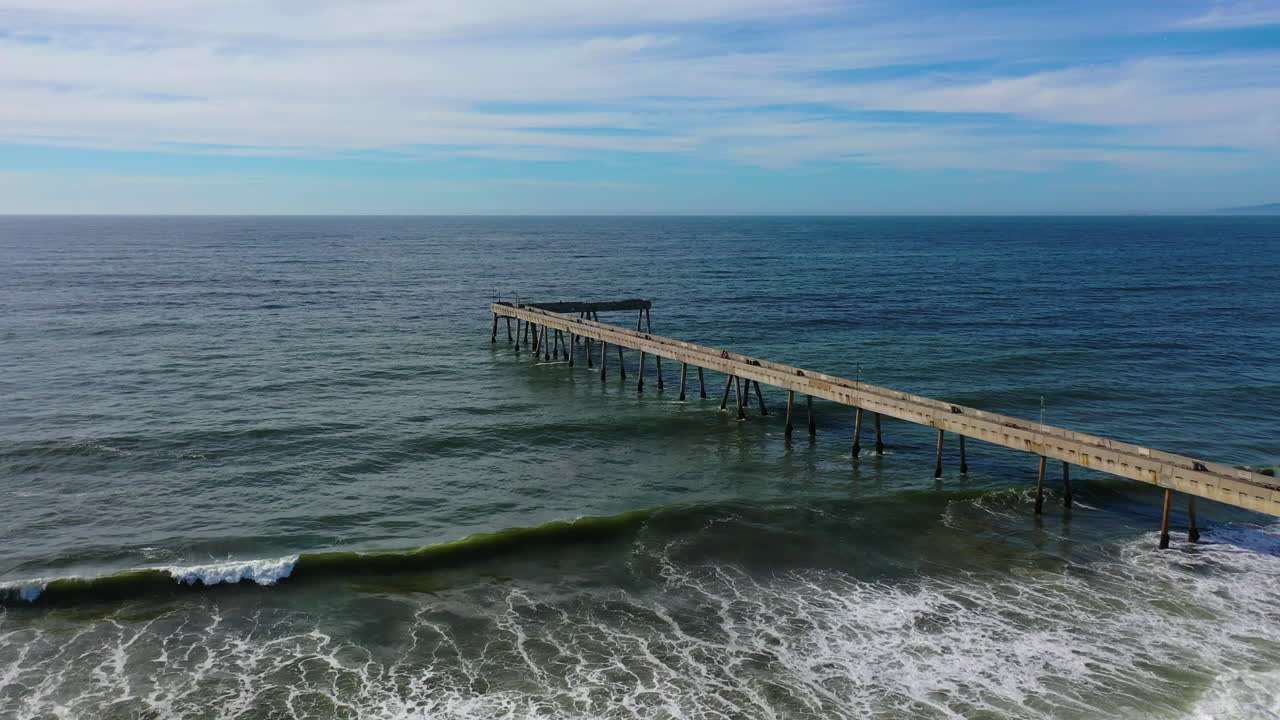 Ripresa aerea inclinata in ascesa sopra il molo municipale di Pacifica nella soleggiata California, USA.