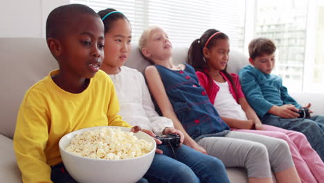 cute children playing video games on the sofa