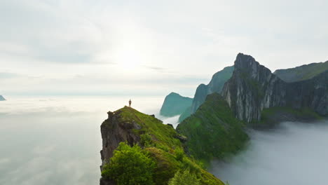 hiker stand on mountain ridge edge overlook majestic arctic norway view