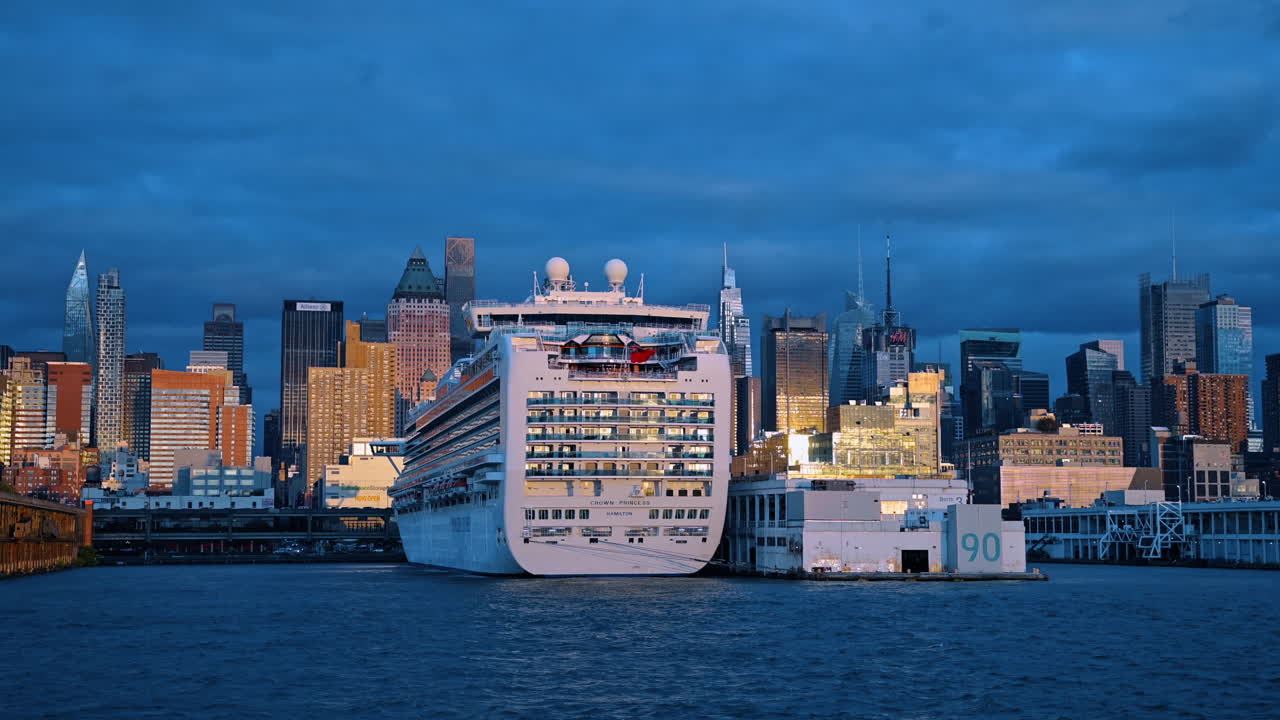 New York, USA, 5 maggio 2025: Nave passeggeri al terminal di Manhattan con riflessi dello skyline della città. Veduta serale di una nave da crociera al Pier 90 a New York City con la luce del tramonto che si riflette