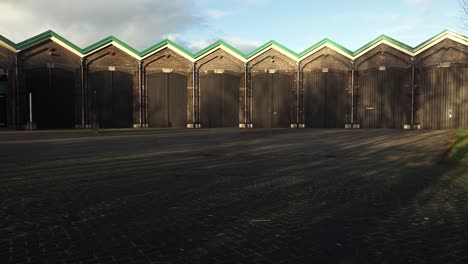 pan down of old tram depot in full sunlight redeveloped building