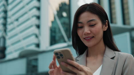 mujer de negocios usando teléfono inteligente al aire libre