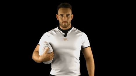 serious rugby player holds rugby ball