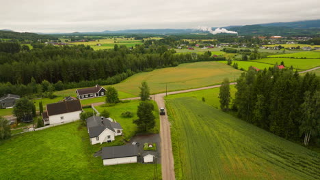 Tractor-Driving-Across-The-Road-Near-Farm-Village-In-South-Eastern-Norway