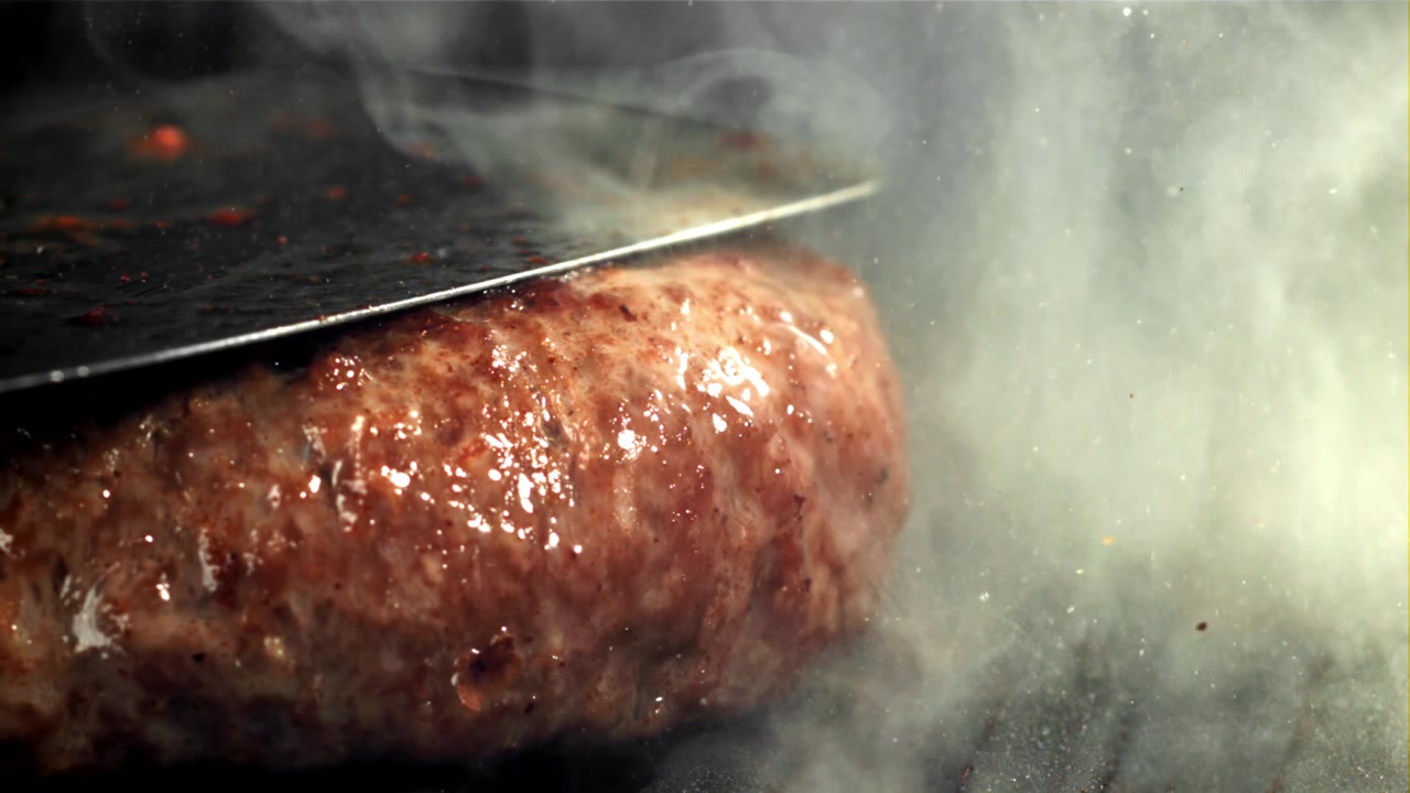 Nærbillede af en saftig bøf, der syder på en varm grill