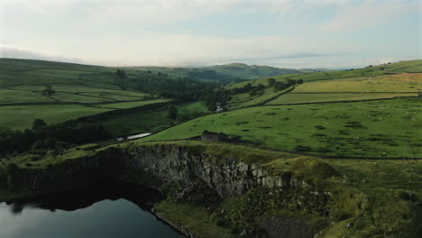 establishing drone shot over disused quarry and barn at golden hour