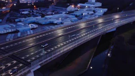Luftaufnahme-Moderne-Beleuchtete-Ruhige-Autobahnspuren-Straßenkreuzung-Tracking-Verkehr-Neigung-Nach-Links-Unten