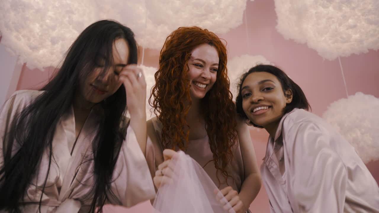 vista inferior de tres amigos multiétnicos bailando en despedida de soltera 2