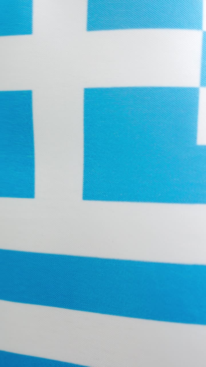 Vertical video of greek national flag waving by the wind