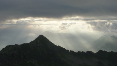 sunrays through the clouds over mountainsridge at sunrise