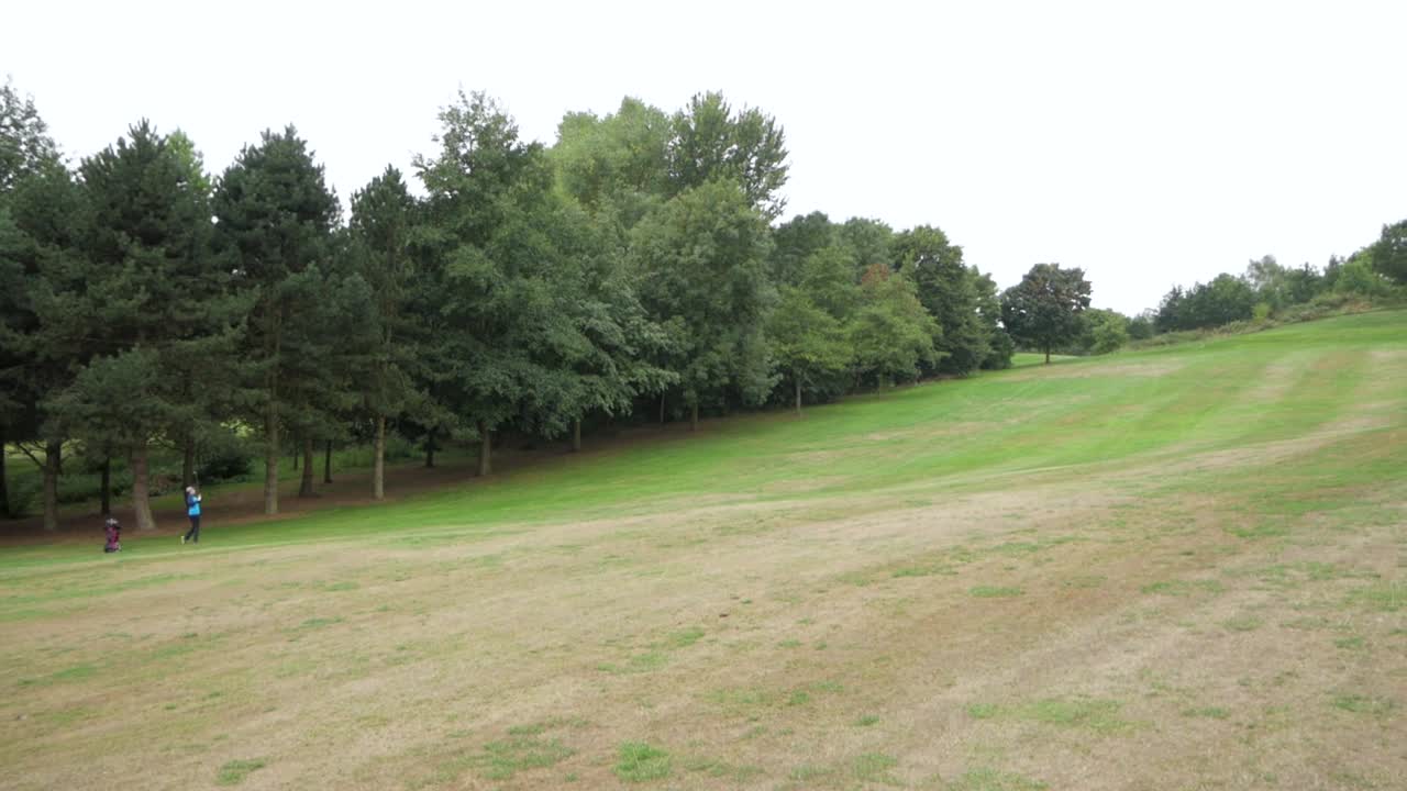 Wide shot of the course as a player hits a shot to the green