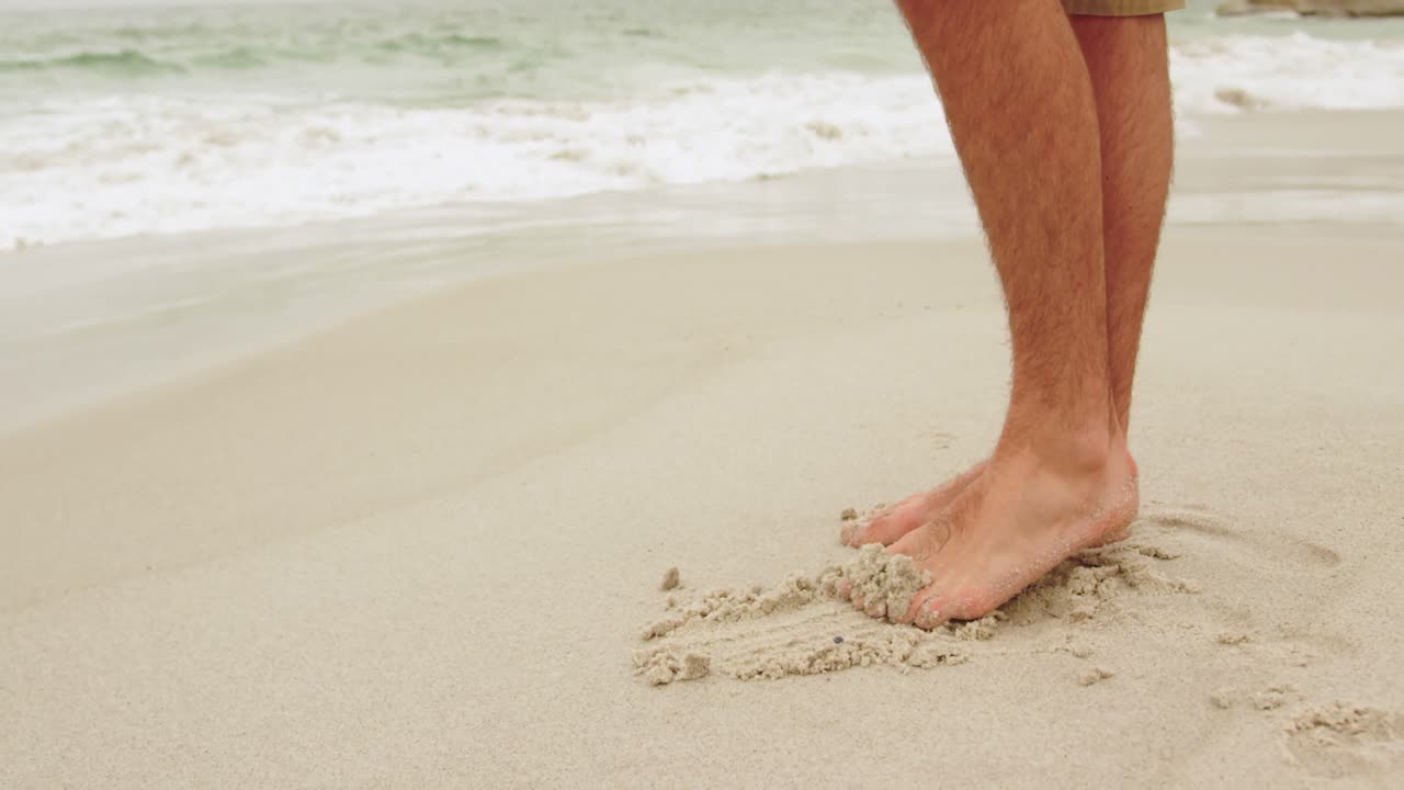 해변 4k에서 모래로 놀고 있는 사람의 낮은 섹션