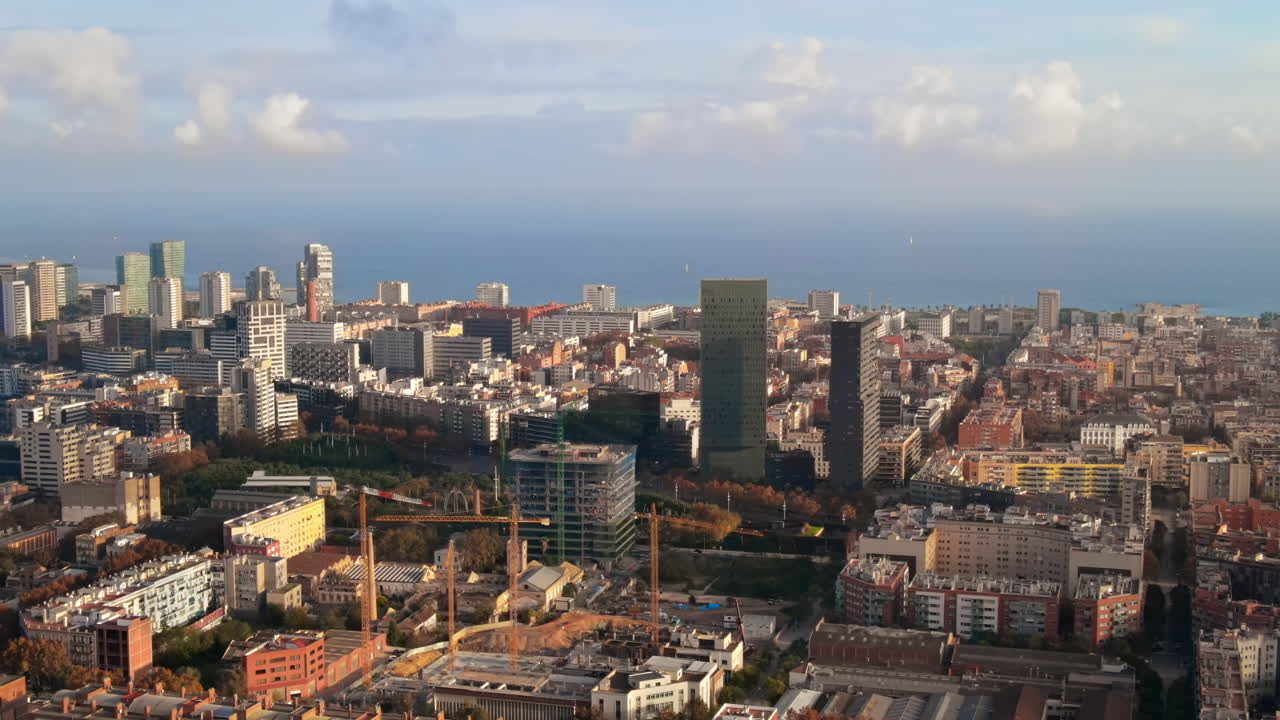 Aerial drone view of Barcelona, Spain. Multiple residential and office buildings, Mediterranean sea in the distance