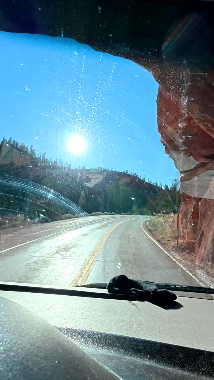 Guidando attraverso un tunnel di roccia rossa su una strada panoramica