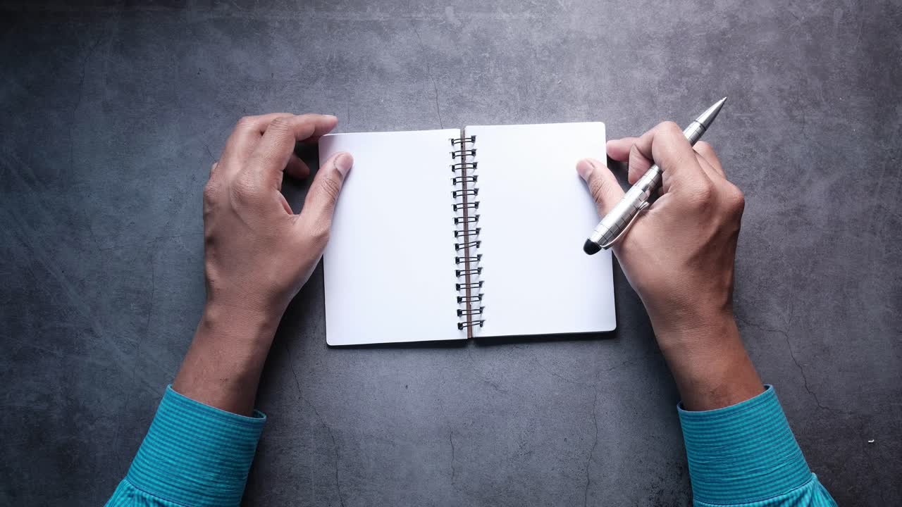 Hands holding a blank notebook and pen