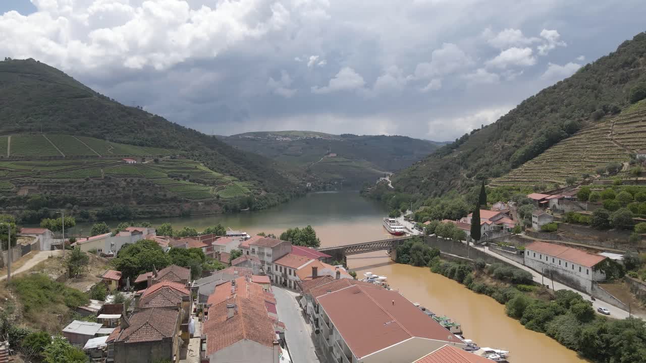 Veduta aerea della città vinicola di Pinhão, Portogallo, drone che avanza sopra i tetti delle case mostrando il fiume Pinhão sulla destra che si unisce al fiume Douro