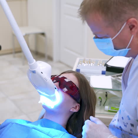 modern equipment at dental clinic. female patient lying in medical chair in special glasses at dentistry center. dentist treating patient with new technology.