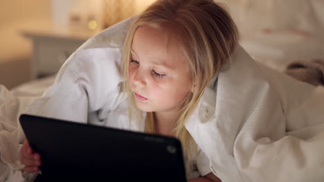 bed, games and girl child with tablet for evening